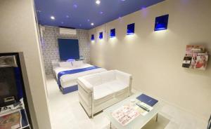 een slaapkamer met een bed en een tafel erin bij CURE in Sumino