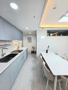 eine Küche mit weißen Schränken und einem weißen Tisch in der Unterkunft 2 Bathrooms & 3 Rooms, New Elevator in Seoul