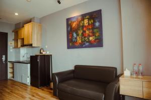 a living room with a couch and a painting on the wall at Twin Tower Hotel & Residence in Surabaya