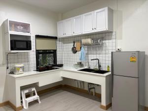 ハジャイにあるAma'homeのシンクと冷蔵庫付きのキッチン