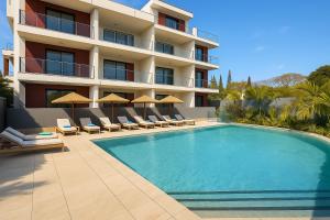 un hôtel avec une piscine dotée de chaises et de parasols dans l'établissement Résidence ORYAM, à Trou aux Biches