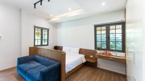 une chambre avec un lit et une chaise bleue dans l'établissement Hoianam Village, à Thăng Bình