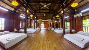 ein Schlafzimmer mit vier Betten in einem Zimmer mit Holzboden in der Unterkunft Hoianam Village in Thăng Bình + 81 Fotos