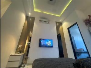 a bedroom with a bed and a tv on the wall at Villa Velare 01 Dharmahusada Indah Galaxy Mall in Surabaya