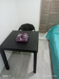 uma mesa preta com uma bolsa roxa em cima de uma cadeira em Alojamientos Jamar em Rionegro mais 2 fotografias