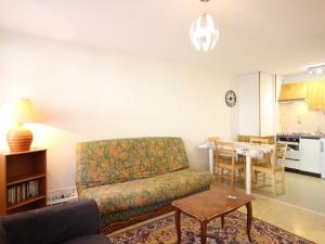 un salon avec un canapé et une table dans l'établissement Confortable F2 bis avec balcon, parking, jusqu'à 5 personnes - FR-1-415-173, à Mont-Dore