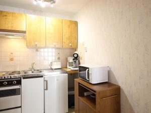 une cuisine avec un évier et un micro-ondes dans l'établissement Confortable F2 bis avec balcon, parking, jusqu'à 5 personnes - FR-1-415-173, à Mont-Dore