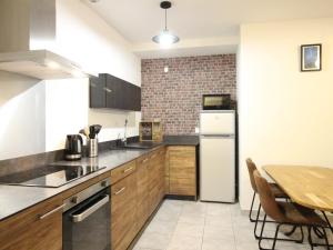 eine Küche mit einem Tisch und einem weißen Kühlschrank in der Unterkunft Beau F3 avec parking et animaux acceptés, proche Thermes - FR-1-415-165 in Le Mont-Dore