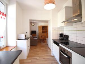eine Küche mit weißen Schränken und schwarzen Arbeitsplatten in der Unterkunft Appartement 55m² centre Mont-Dore, 2 chambres, parking, animaux admis - FR-1-415-194 in Le Mont-Dore + 4 Fotos