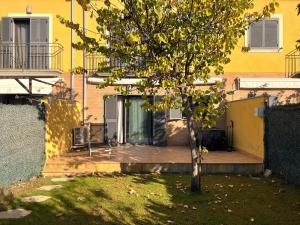 ein Baum in einem Hof neben einem gelben Gebäude in der Unterkunft Casa adosada con piscina. Paradis St Pere - ES-89-147 in Sant Pere Pescador