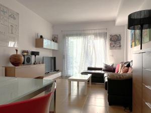 ein Wohnzimmer mit Sofa und Tisch in der Unterkunft Casa adosada con piscina. Paradis St Pere - ES-89-147 in Sant Pere Pescador