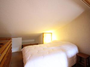 - une chambre avec un lit blanc éclairé dans l'établissement Duplex F2 au Mont-Dore avec Garage Privé - FR-1-415-167, à Mont-Dore 6 autres photos