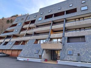 un immeuble d'appartements avec des panneaux solaires sur sa façade dans l'établissement Duplex F2 au Mont-Dore avec Garage Privé - FR-1-415-167, à Mont-Dore