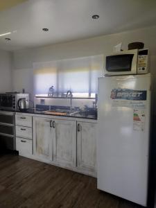 a kitchen with a refrigerator and a microwave at Portal del Lago - Casa confortable cerca del lago - Hermoso atardecer in Federación