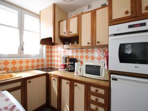 a kitchen with a microwave oven and a counter top at Appartement T2 Centre-Ville, 6 Couchages - FR-1-415-189 in Le Mont-Dore