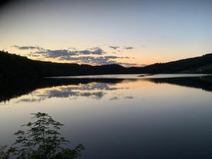 a view of a large lake at sunset at Appartement T2 Centre-Ville, 6 Couchages - FR-1-415-189 in Le Mont-Dore +7 photos