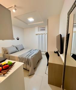 a hotel room with a bed and a television at Moderno com piscina e perto da praia in Rio de Janeiro