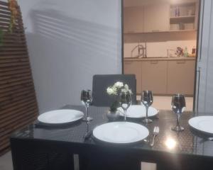 a table with plates and wine glasses and flowers on it at Éden Home Accès Rivière Privée in Goyave