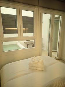 a bedroom with two towels on a bed with a window at Cala Arena-few steps from the beach in La Cala de Mijas