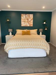 une chambre avec un grand lit avec deux tables de nuit dans l'établissement Clonburn Manor at Sovereign Hill, à Ballarat