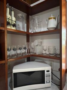 a kitchen with a microwave and glasses on shelves at Vida buena in Drake +22 photos