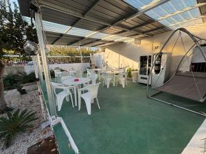 eine Terrasse mit weißen Tischen und Stühlen sowie ein Zelt in der Unterkunft Da Don Antonio in Trecase