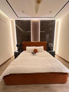 een slaapkamer met een groot bed en een witte deken bij Zeta Mall 2 bedroom Apartment with Swimming Pool in Islamabad
