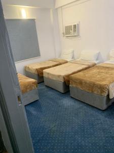 الشقق الأولى السكنية في المدينة المنورة: ثلاثة أسرة في غرفة مع لوحة طباشير