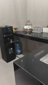 une cuisine avec un plan de travail noir avec un évier dans l'établissement The Hunian, à Seminyak