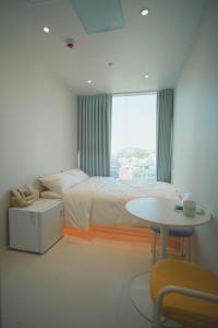 una camera da letto con un letto, un tavolo e una finestra di Stay Hello Hongdae Sinchon a Seul