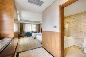 a hotel room with a bed and a bathroom at 青岛机场富华酒店 in Qingdao