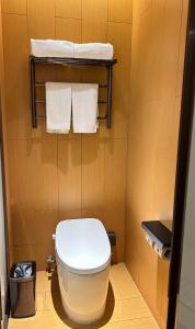 ein kleines Badezimmer mit einer weißen Toilette und Handtüchern in der Unterkunft JI Hotel Shanghai Meiling North Road Subway Station in Shanghai