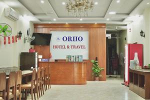 a restaurant with a table and chairs and a sign at Oriio Hotel in Cat Ba
