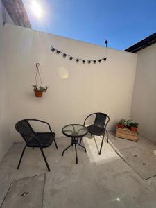 a patio with two chairs and a glass table at Casa en el centro de Carmelo in Carmelo
