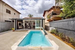 a swimming pool in the backyard of a house at Casa no Litoral , com Piscina Privativa em Ubatuba in Ubatuba
