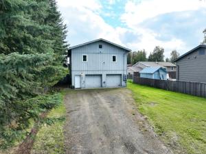 a white barn on a dirt road in a yard at The Upper Downtown Suite 2 in Fairbanks