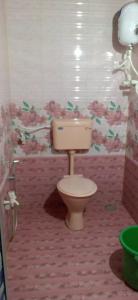 a bathroom with a toilet in a room with flowers on the wall at Holiday Home Beach Resort And Aquatic Sports In Tarkarli in Malvan +17 photos