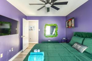 a bedroom with a green bed and purple walls at BoardGame Bungalow in Atlantic City