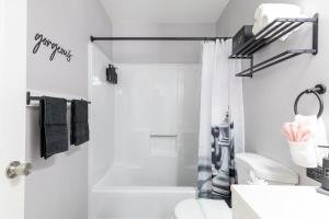 a white bathroom with a shower and a toilet at BoardGame Bungalow in Atlantic City +24 photos
