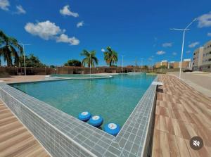ein Schwimmbecken mit blauen Hockern im Wasser in der Unterkunft Apartamento com piscina e academia in João Pessoa + 7 Fotos