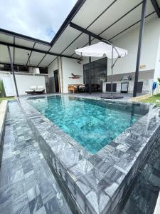 una piscina con acqua blu in una casa di Sakhu Art Villa a Nai Yang Beach