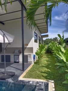a backyard with a swimming pool and a house at Sakhu Art Villa in Nai Yang Beach