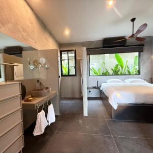 una camera da letto con un letto e un lavandino in una stanza di Sakhu Art Villa a Nai Yang Beach