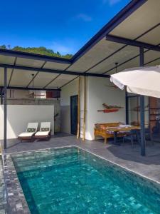 una piscina con tavolo e ombrellone di Sakhu Art Villa a Nai Yang Beach