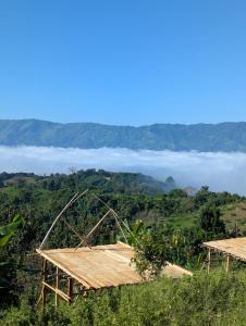 a view from the top of a hill with clouds in the background at Toma Tungi Resort & Restaurant in Bāndarban +7 photos