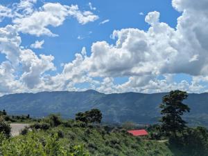 a view of the mountains with a blue sky and clouds at Toma Tungi Resort & Restaurant in Bāndarban