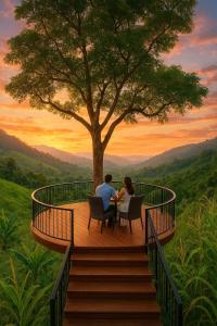 a man and woman sitting at a table under a tree at Toma Tungi Resort & Restaurant in Bāndarban