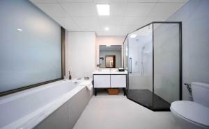 La salle de bains est pourvue d'une baignoire, d'une douche et de toilettes. dans l'établissement Xiamen Weir Hotel, à Gaolin