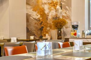 une salle à manger avec des tables et des chaises et un tableau dans l'établissement Xiamen Weir Hotel, à Gaolin