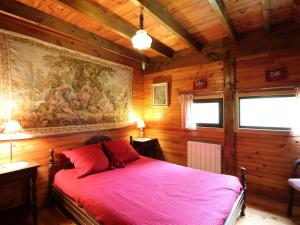une chambre avec un lit rouge avec un tableau sur le mur dans l'établissement Chalet au Mont-Dore, 3 chambres, terrasse et parking, 8 couchages - FR-1-415-208, à Mont-Dore